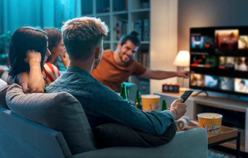 Freunde schauen gemeinsam Fernsehen auf einem Smart TV