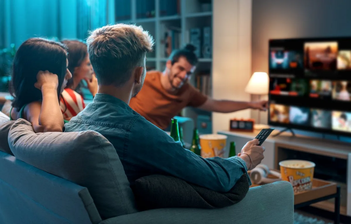 Freunde schauen gemeinsam Fernsehen auf einem Smart TV